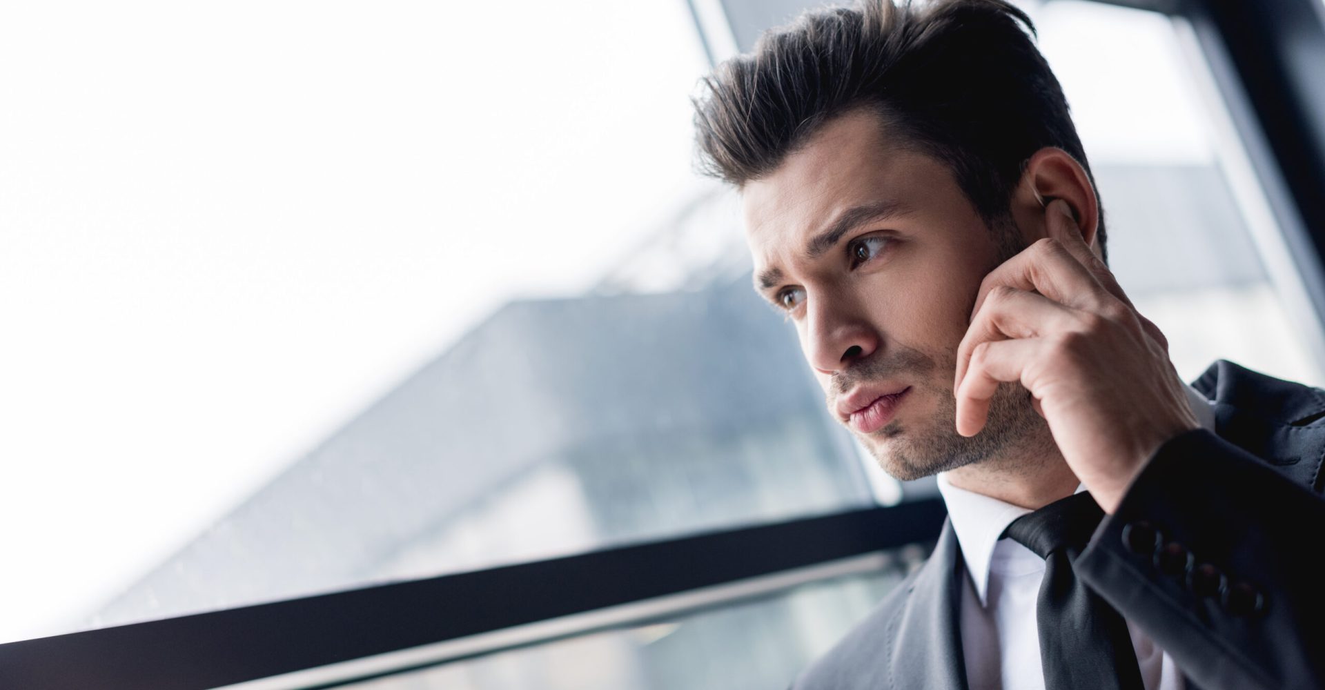 focused handsome bodyguard in suit using earphone focused handsome bodyguard in suit using earphone